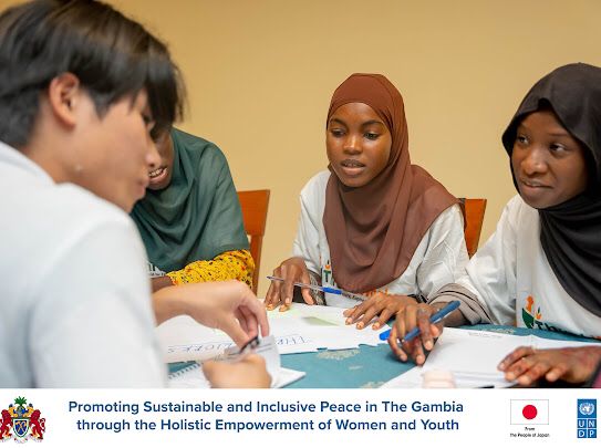ThreshWorks members and a Japanese student in close discussion at the UNDP exchange table